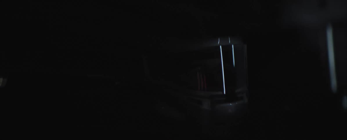 Person driving a vehicle in a dark environment with minimal light visible through the windshield