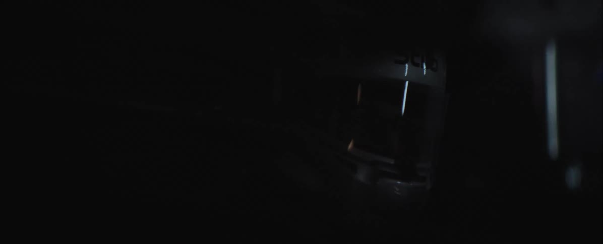 The man in the helmet has light reflecting off of his helmet in the dark