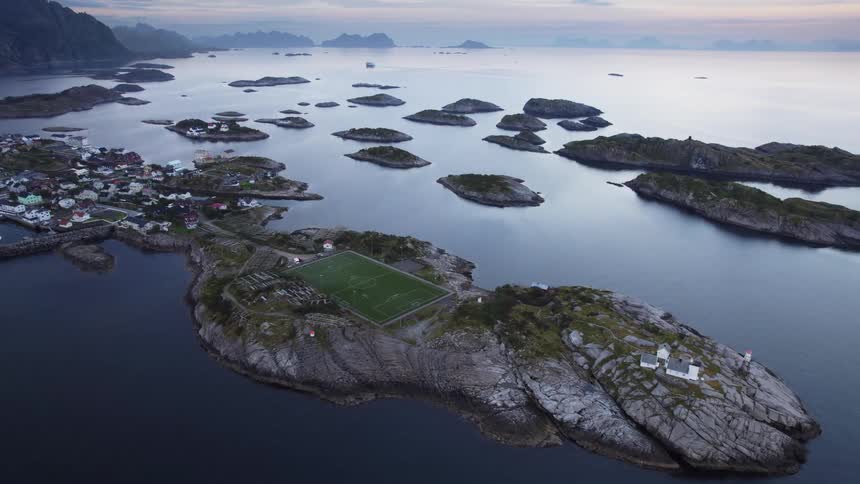 Aerial view of a coastal archipelago with rocky islands scattered villages and a soccer field near the sea