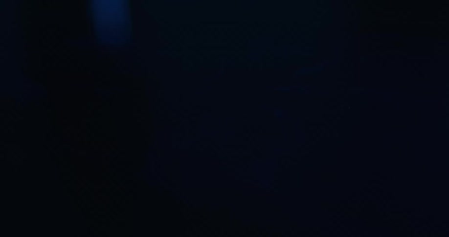 Blue light shines on a dark surface creating abstract square and rectangular reflections in a mysterious nighttime atmosphere