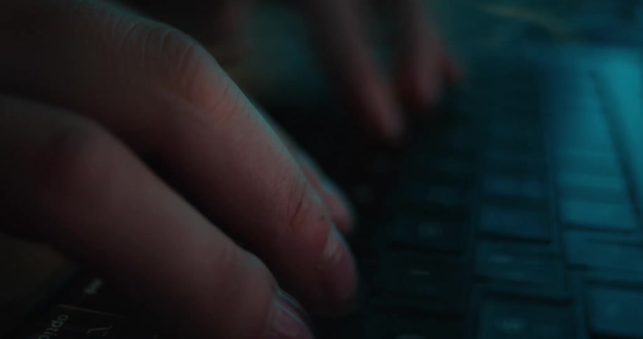 Female hands typing on the keyboard of a laptop computer indoors