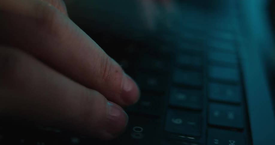 The fingers are striking keys on the black keyboard
