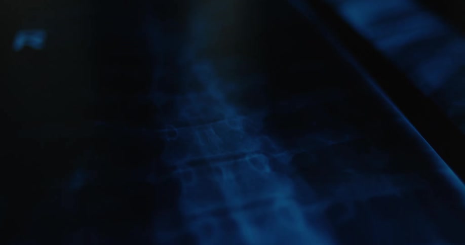 A dark room with a screen faintly displaying an image