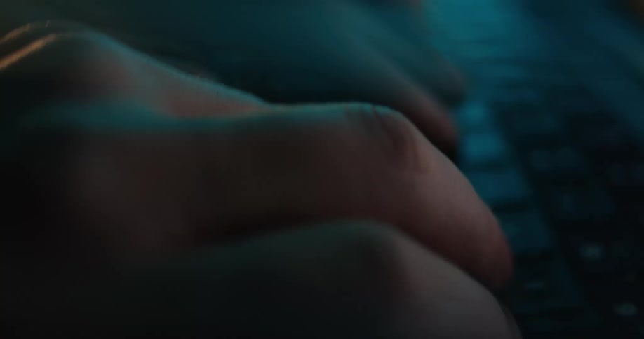 Female hands typing on the keyboard of a laptop computer indoors