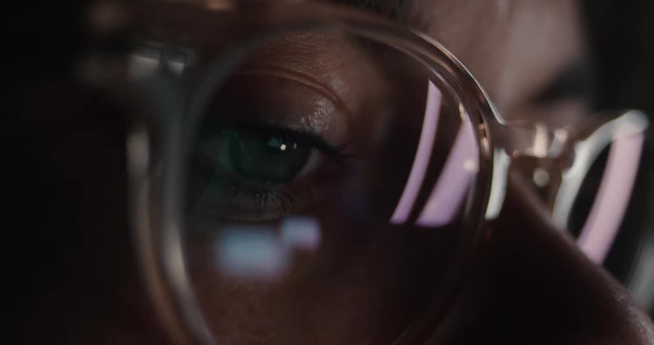 A close up of a persons eye through a pair of glasses