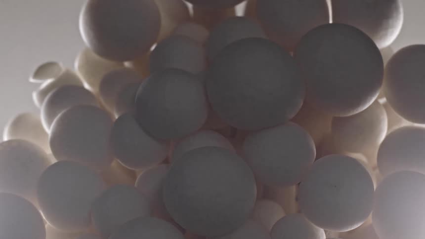 The video shows a tight shot of a large cluster of small pale rounded mushroom caps the lighting is soft highlighting the texture and shape of the fungi possibly white shimeji or beech mushrooms
