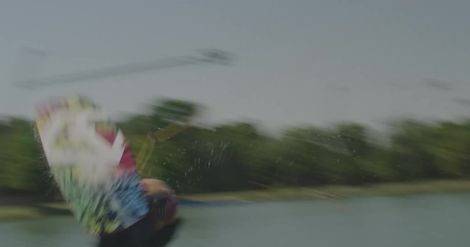 Wakeboarder performing a jump while being pulled by a cable over the lake