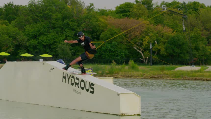 Man riding a wakeboard on a hydrous obstacle