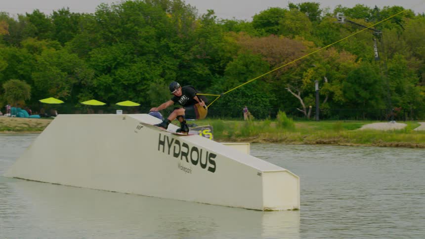 Wakeboarder sliding on a hydrous obstacle while attached to a tow cable