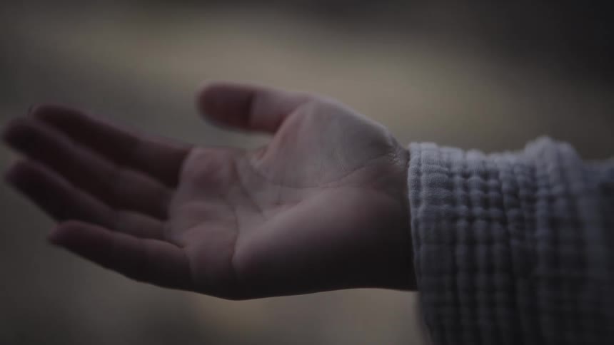 Outstretched hand catching a drop of water