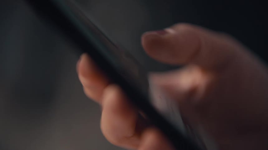 A womans hand is scrolling on a smartphone