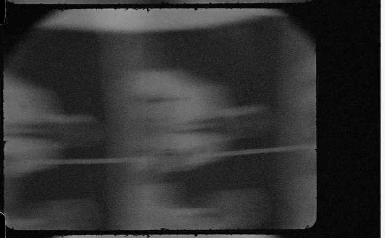 Blackandwhite film showing two duplicated human figures in a split frame
