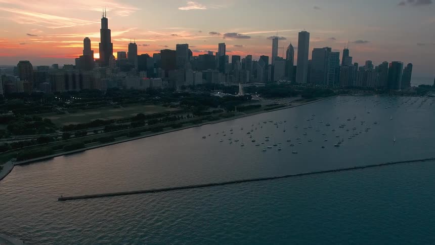 Buildings and towers on the chicago city skyline as boats sail on the water