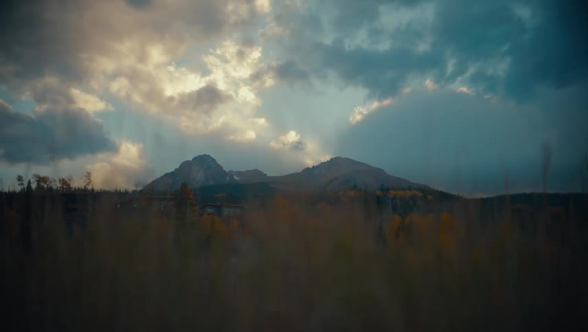 Rugged mountains with dramatic clouds and sun rays in a serene landscape
