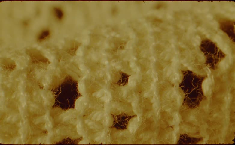 An extreme closeup of knitted fabric fibers creating a soft textured pattern