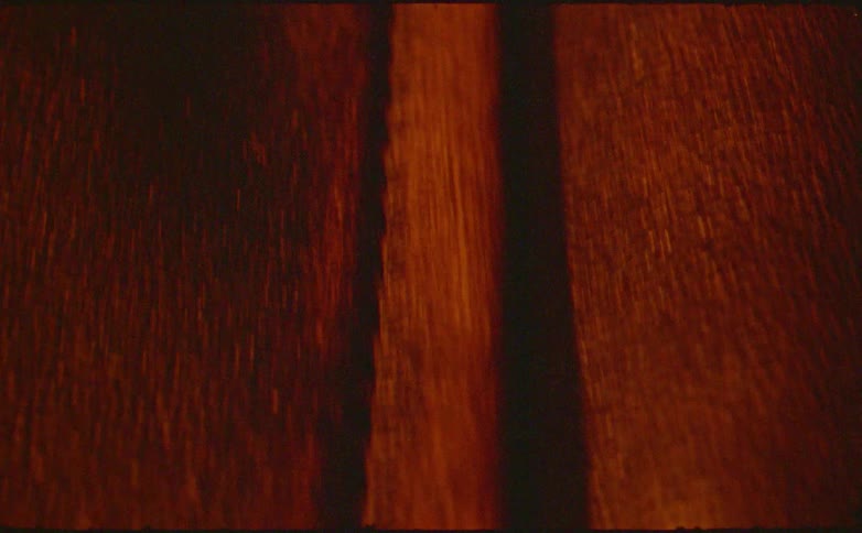 Textured golden colored object sits on a wooden surface