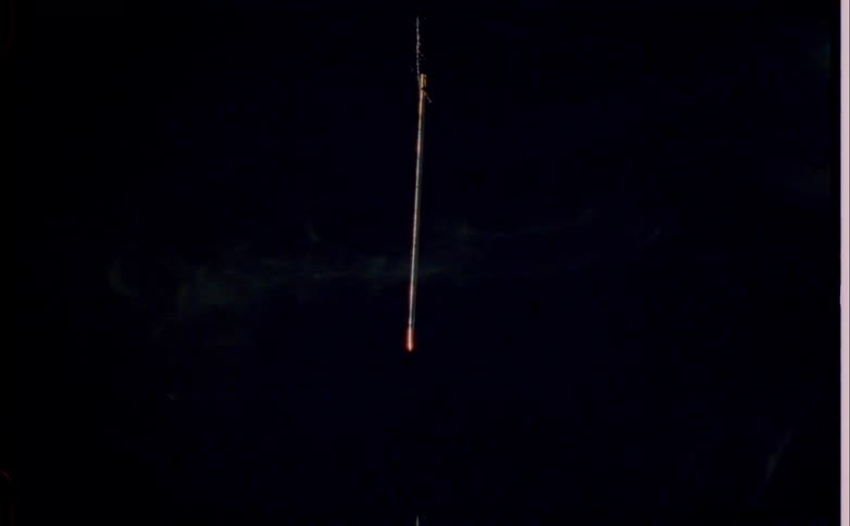 Close up of a dangling burning stick outdoors at night