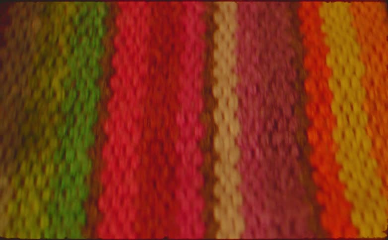 A fabric featuring a woven pattern made up of rainbow colors