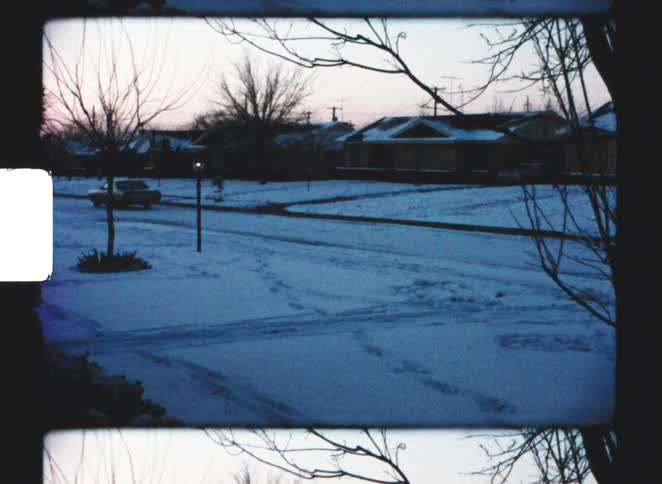A car driven down a street in a suburban neighbourhood