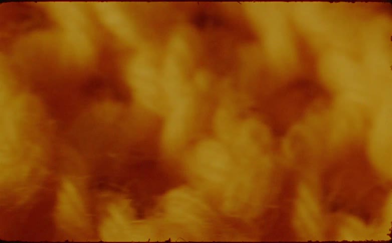 The video provides an extreme closeup of a fibrous woven material likely a chunky yarn or knitted fabric characterized by soft indistinct textures and a warm goldenbrown color palette