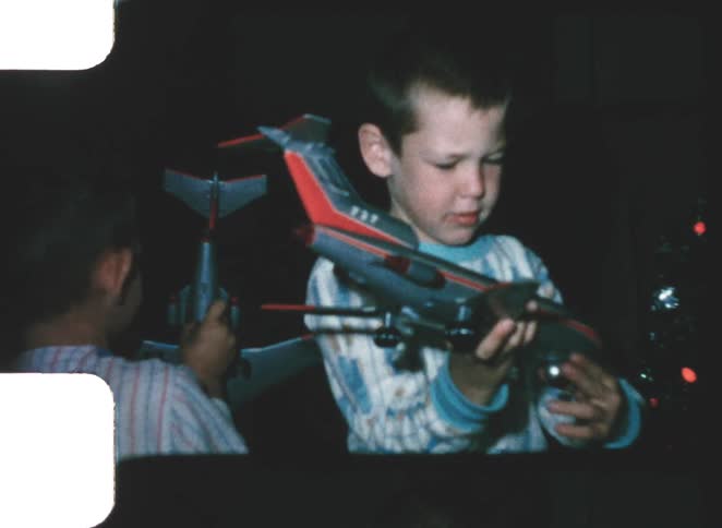 Two kids playing with toy planes on christmas