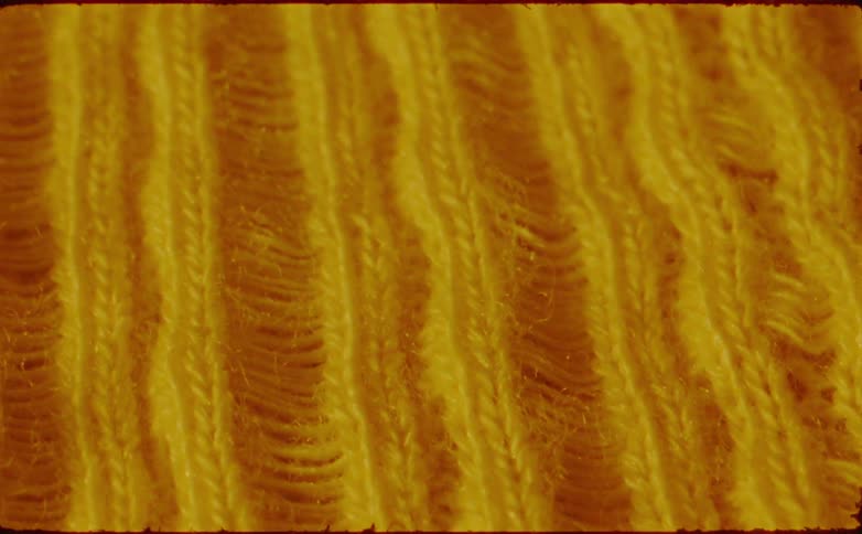 An abstract close view of yellow vertical yarn texture with a moving blur effect and a vintage film border