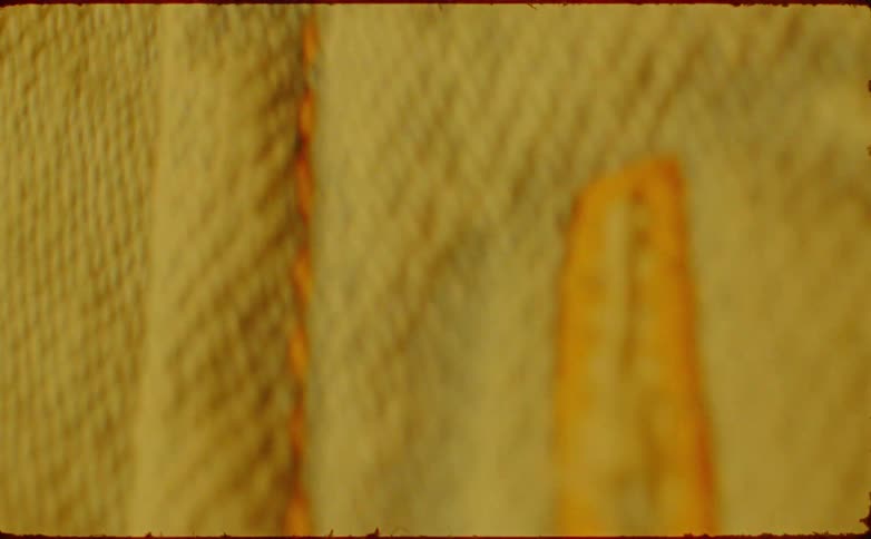 A close view of yellow vertical yarn texture with a moving blur effect and a vintage film border
