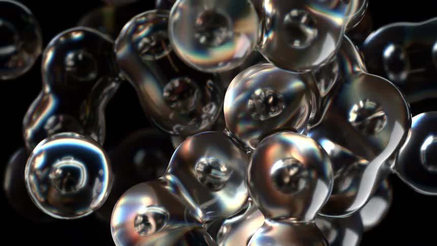 Iridescent glass like bubbles float and morph fluidly against a black background