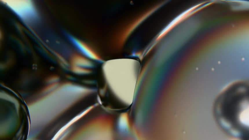 Closeup of iridescent bubbles floating against a dark background with glossy reflections