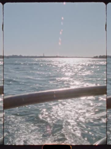 Boat moving across the water with the sun reflecting brightly on the surface