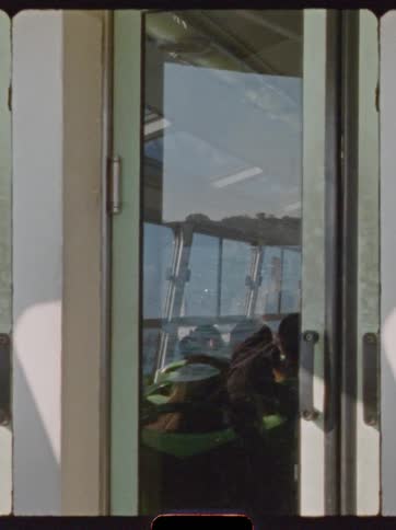Glass doors on a ferry reflect the ocean on a summer day