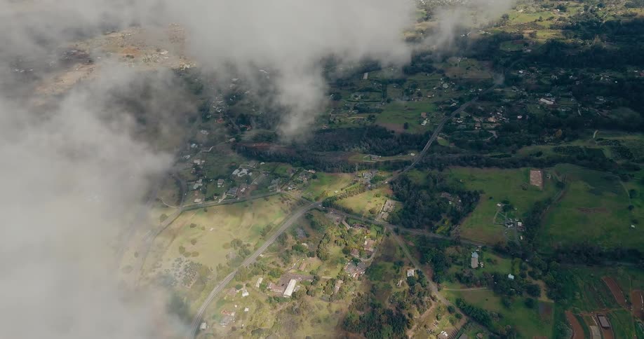 Clouds partially obscure towns in the rural countryside on a summer day