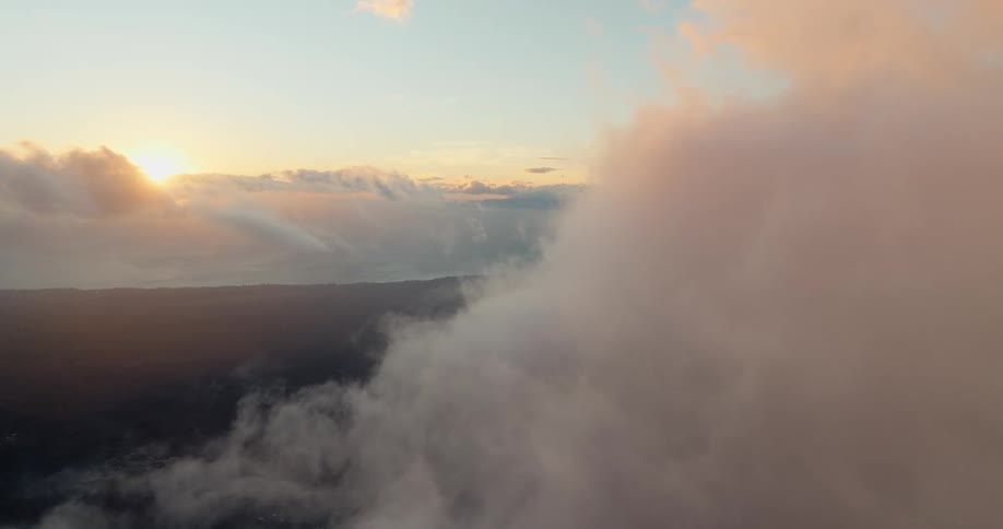 Low clouds covering a wide landscape with the sky lit by the sun near the horizon