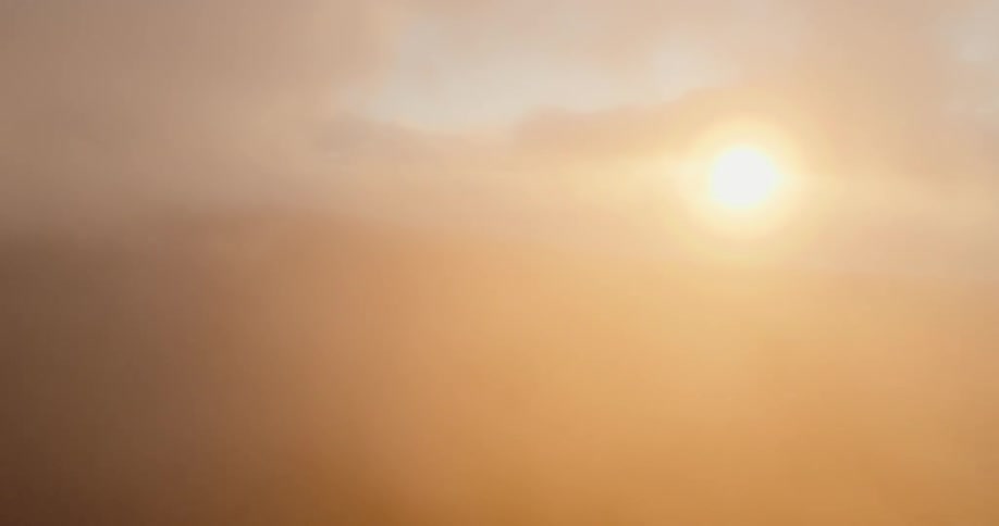 A view of the sun in the distance with clouds