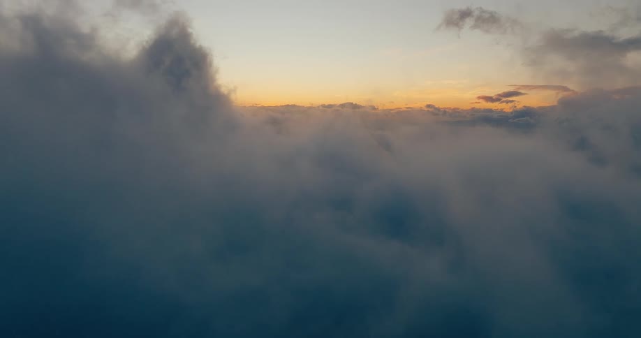 Dense cloud layer seen from above with the horizon lit by the sunset