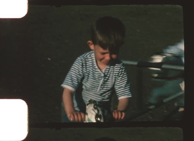 Child sitting on a rideon toy with handlebars in an outdoor setting