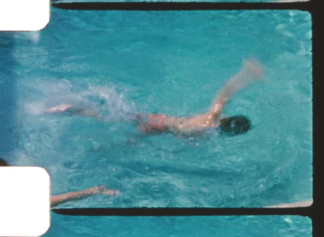 A boy swims in a bright turquoise pool with a striped white and green border captured in a vintage 8mm film look with perforations