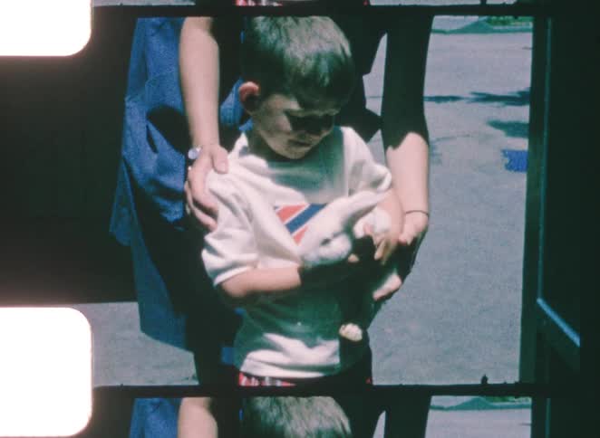 A child holding a pet rabbit outdoors