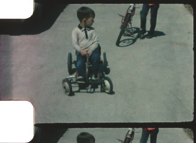 Two kids riding on bikes and toys