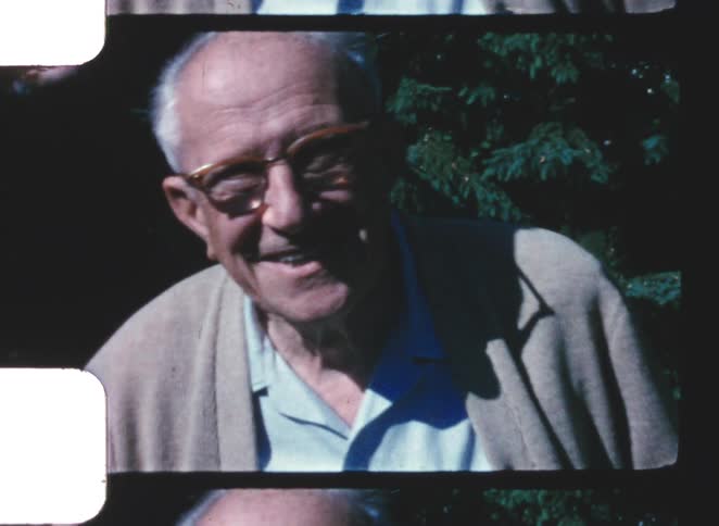 Elderly man smiling in an old film recording outdoors