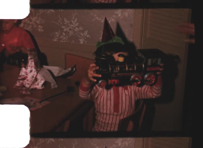 Child holding a toy train in a party setting