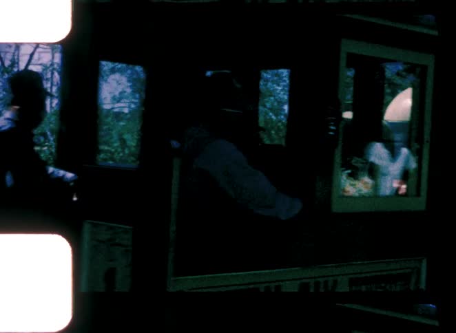 Train in motion with tree reflections on the windows and visible metal components