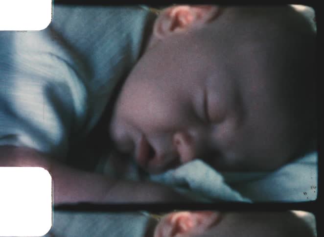 The baby is sleeping on a blanket