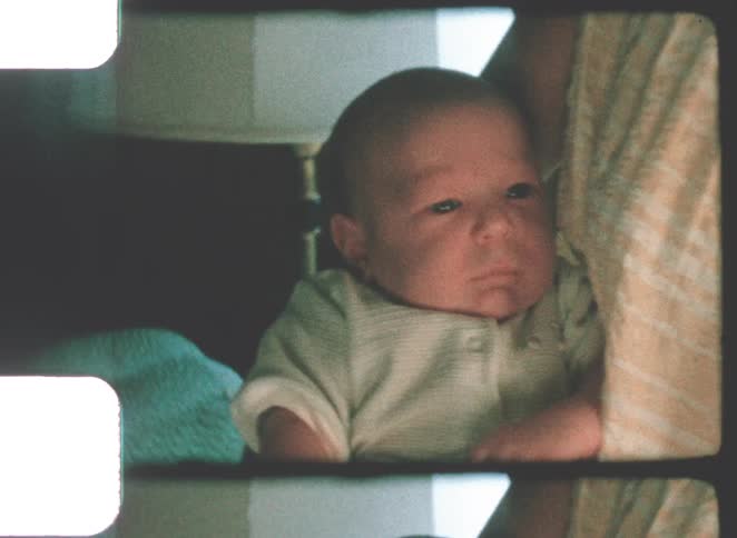 A portrait of a baby yawning in a room