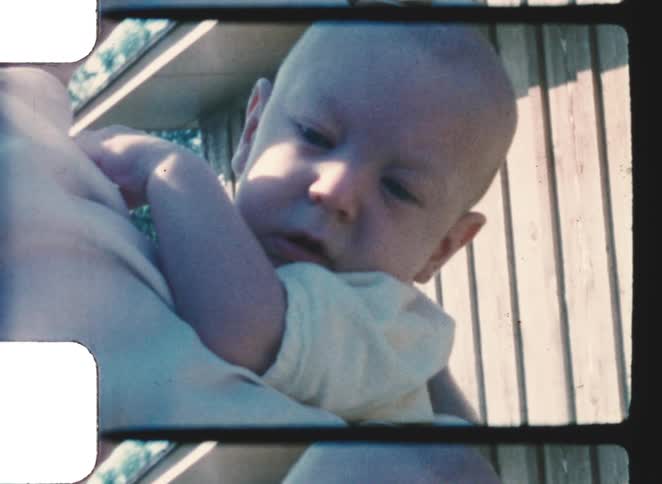 A mother holding a baby outdoors