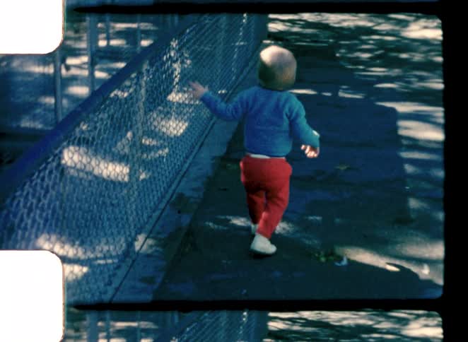 The boy tried to climb the fence in the park