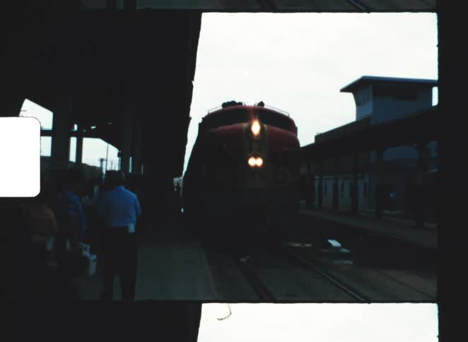 Train approaching the station with people on the platform