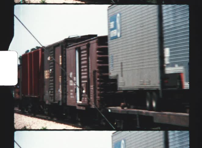 The train is transporting large storage containers