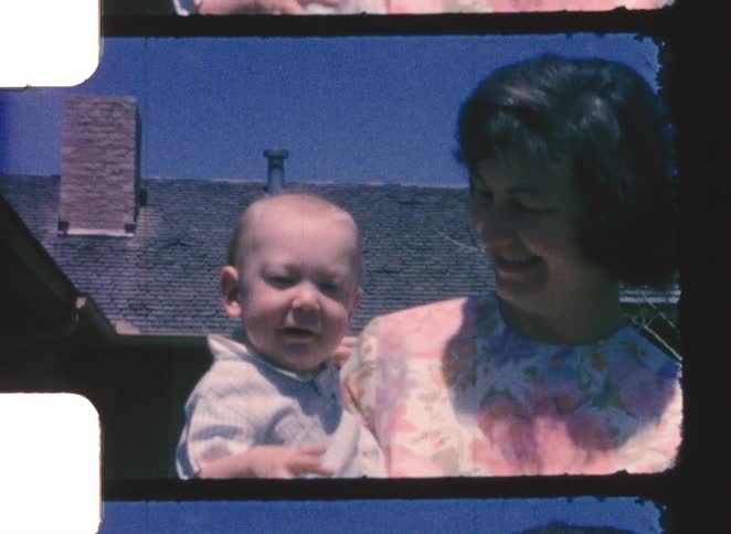 The woman is holding a happy baby