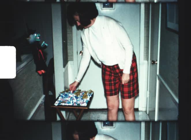 The woman picks up and tosses a piece of candy